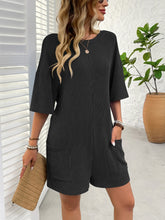 Side shot of black romper with subtle stripe detail and pockets.