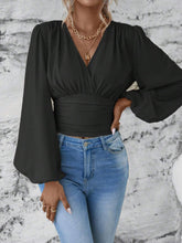 Front view of the black Balloonique™ Blouse highlighting smocked neckline and balloon sleeves, paired with light blue washed jeans, and jewelry.