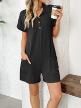 Black short sleeve romper on model, front view with sleek styling.