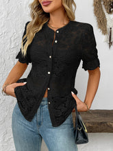 Model wearing the black lace button-down shirt at an outdoor café, paired with a black leather handbag and tan sandals for a chic, effortless brunch look.