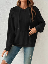 Front view of a woman wearing the Calvessa Hoodie in black, styled with a laid-back fit, ribbed texture, and soft, breathable fabric.