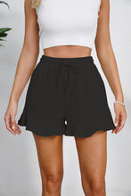 Model in black Plus Size Drawstring Ruffle Hem Shorts with front tie drawstring and delicate ruffle trim.