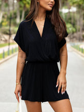 Close-up of surplice neckline and textured weave fabric, highlighting quality construction and flattering detail, in black.