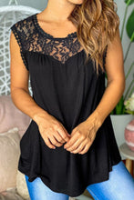 Woman in black lace trim tank paired with denim shorts and sandals for a casual daytime look.