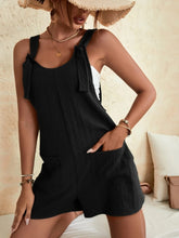 Model wearing black romper with blazer and heels for an elevated day-to-night transition look.