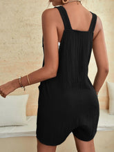 Full back view of black romper with relaxed shape and soft textured fabric.