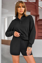 Woman in a black Half-Button Sweatshirt and Shorts Active Set posing for a picture.