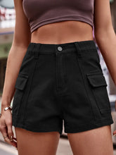 Close-up of the textured rayon fabric of the black Joyful Journey Denim shorts as a woman sits on a park bench.