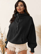 A model wearing the black color Nuvella Zip-Up Dropped Shoulder Hoodie paired with distressed tan denim shorts.