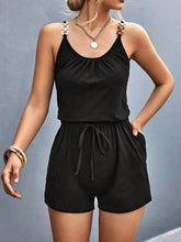 Model wearing Sunkiss Move Romper in black, showcasing scoop neckline, adjustable buckle straps, and elastic drawstring waist.