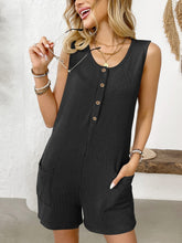 Model in black romper showing front details, including round neckline, half-button-up front, and side pockets—sleek, timeless, and flattering.