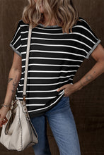 Model wearing striped knit round neck short sleeve top, front view in black and white stripes, paired with denim jeans.