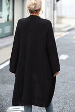 Back image of model in black cardigan showing below-knee length and clean lines