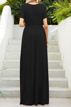 Back view of a model showcasing the black Blissurella Maxi Tee Dress styled with gold jewelry for a chic everyday brunch look.