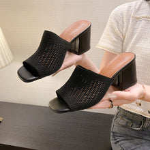 Model holding black Block Heel Knit Sandals showcasing eyelet design
