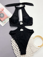 Front flat lay of black cutout halter neck one-piece swimwear showing cutout detail and adjustable halter straps