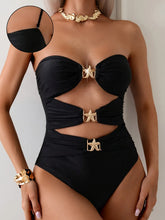 Model wearing black cutout sweetheart neck one-piece swimwear front view with gold starfish accent