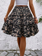 Back view of black Florévyn Midi Skirt showcasing frill tiers and ruffled hem