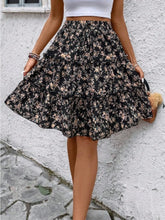 Black Florévyn Midi Skirt with floral print, frill tiers, and ruffled hem styled with white tube top