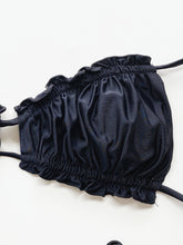 Black frill trim halter neck bikini set close up highlight frill trim and adjustable tie