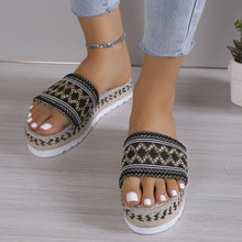 a model wearing a black pair of Geometric Weave Platform Sandals