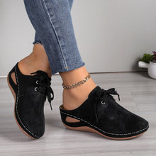 Front view of black Lace-Up Round Toe Wedge Sandals and a gold anklet and blue jeans.