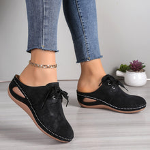Side view of the black Lace-Up Round Toe Wedge Sandals and a gold anklet and blue jeans.