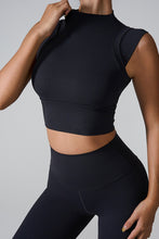 Side view of woman in black mock neck active tank top.