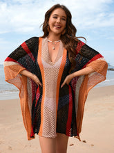 Model wearing black openwork color block plunge cover-up with deep V-neckline at beachside setting