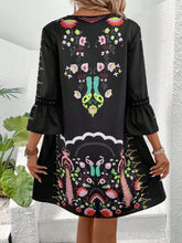 Back view of woman in Black Qelorian Lace Mini Dress featuring three-quarter lace sleeves, lace-trimmed back neckline, and flowing floral accents.
