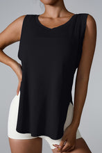 Model wearing black slit round neck active tank in athleisure look outdoors.