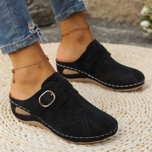 Side angle of black Suede Round Toe Wedge Sandals showcasing strap and gold buckle detail