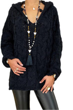 Model wearing the Tessyra Black Cable-Knit Hooded Sweater paired with jewelry and black leather pants.