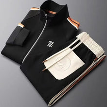 Neatly folded Varnox LuxeTrak jacket and pants set in black.