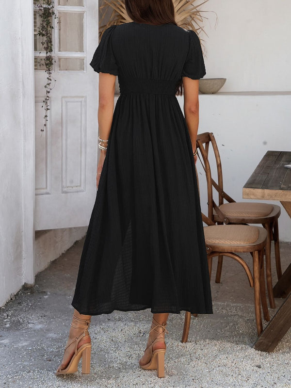 Back view of black Velunira dress highlighting button detail and midi hem.