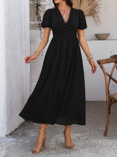 Model in black Velunira dress showcasing V-neckline and puff sleeves.