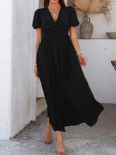 Side profile of black Velunira dress featuring textured fabric and silhouette.