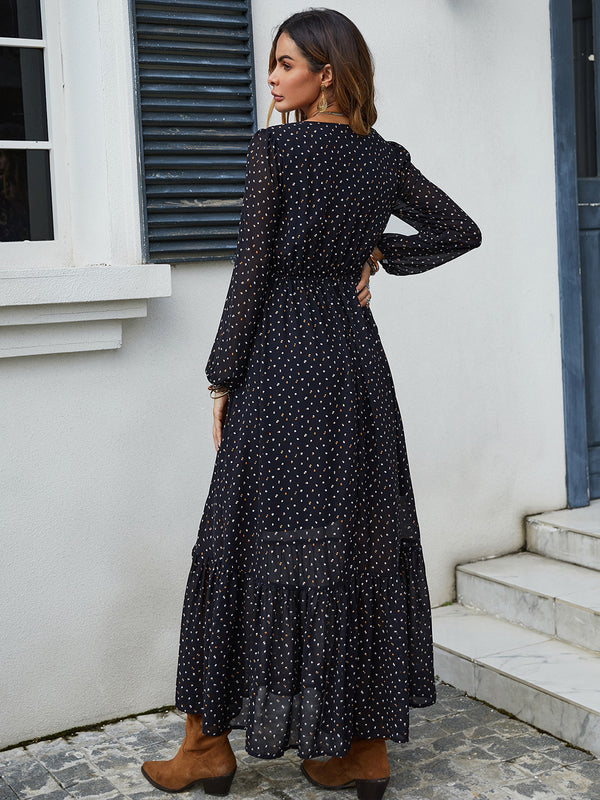  Back view of black Veyonna dress showcasing flowing silhouette, ruffled hem, and polka dot fabric.