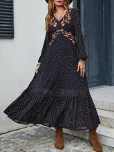 Front view of black Veyonna dress with V-neckline, balloon sleeves, floral chest embroidery, and polka dot design.