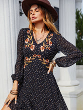 Close-up side profile of black Veyonna dress featuring balloon sleeves, embroidered detail, and breezy ruffled hem.