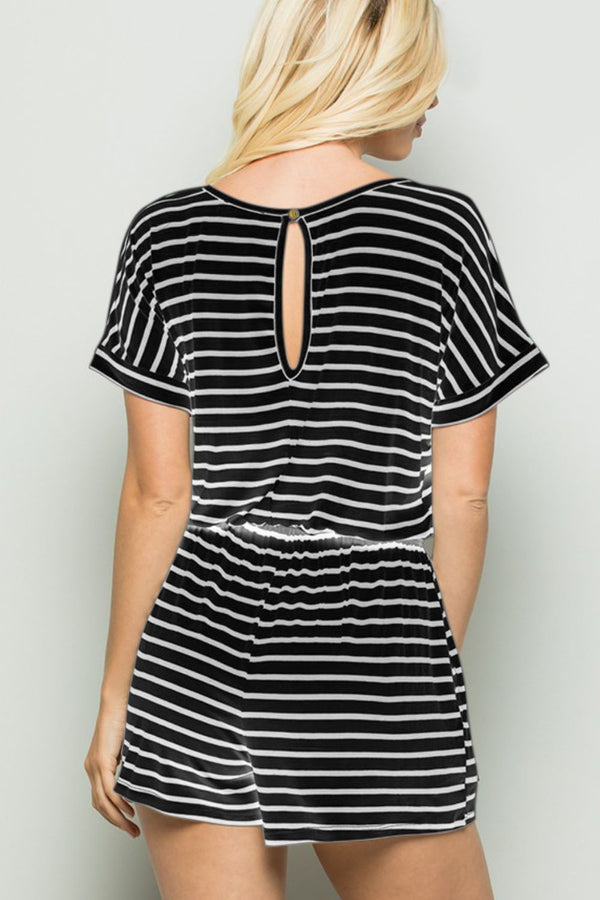 Back view of model wearing striped romper showing back button closure, soft breathable fabric, and blackivory vertical stripe design.