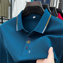 Close-up front view of blue Royale Crest Fleur de Lis Polo showing embroidered placket detail.
