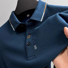 Zoomed in front view of blue Royale Crest Fleur de Lis Polo showing quality fabric texture.