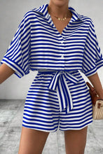 Close-up of blue striped romper’s collared neckline, button-up front, and waist tie.