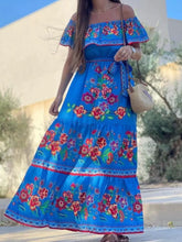 Front view of blue floral Isadorae Dress paired with statement earrings.