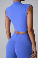 a model posing the back view of the Blue color Mock Neck Active Tank