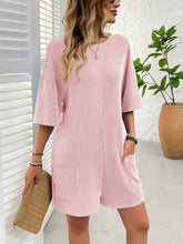 Side profile of blush pink romper showing textured fabric and practical pockets.