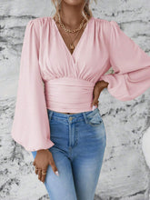 Front view of the blush pink Balloonique™ Blouse highlighting smocked neckline and balloon sleeves, paired with light blue washed jeans, and jewelry.