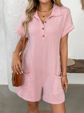 Close-up of blush pink romper's button detail and textured fabric.