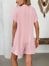 Blush pink romper shown from back on model with soft natural lighting.